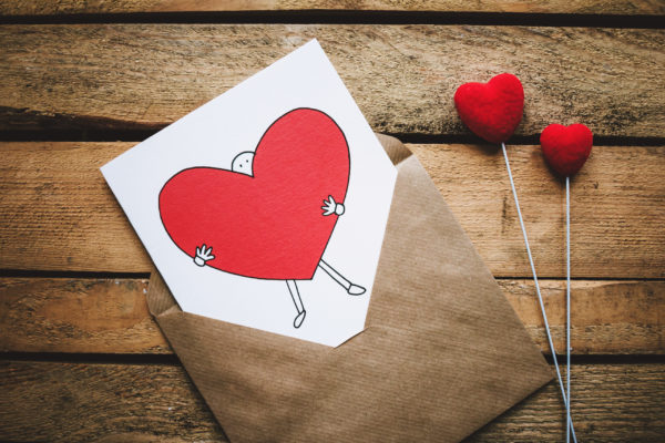 Canva - White, Black, and Red Person Carrying Heart Illustration in Brown Envelope